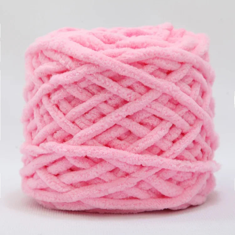 A ball of pink chenille knitting yarn used for hand crafting.
