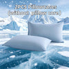 Two white pillowcases without a core displayed on an icy blue surface with a snowy mountain background