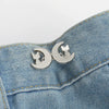 Silver crescent moon button clips featuring a cat silhouette attached to denim fabric