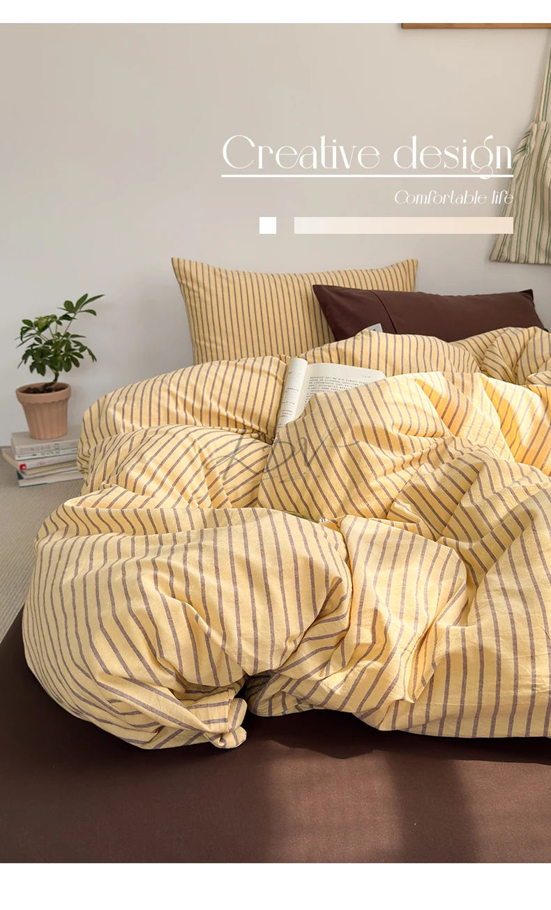 A yellow and beige striped duvet cover set displayed on a bed with brown accents.