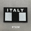 A black rectangular patch with the word ITALY in white text and two square sections featuring a geometric pattern.