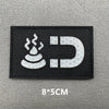 Black embroidered patch featuring a stylized flame and the letter D on a gray background.