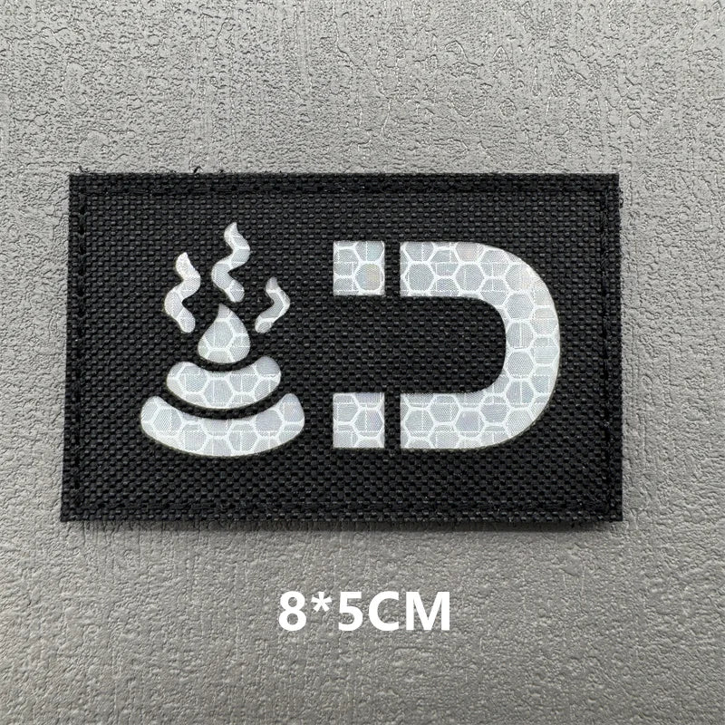 Black embroidered patch featuring a stylized flame and the letter D on a gray background.