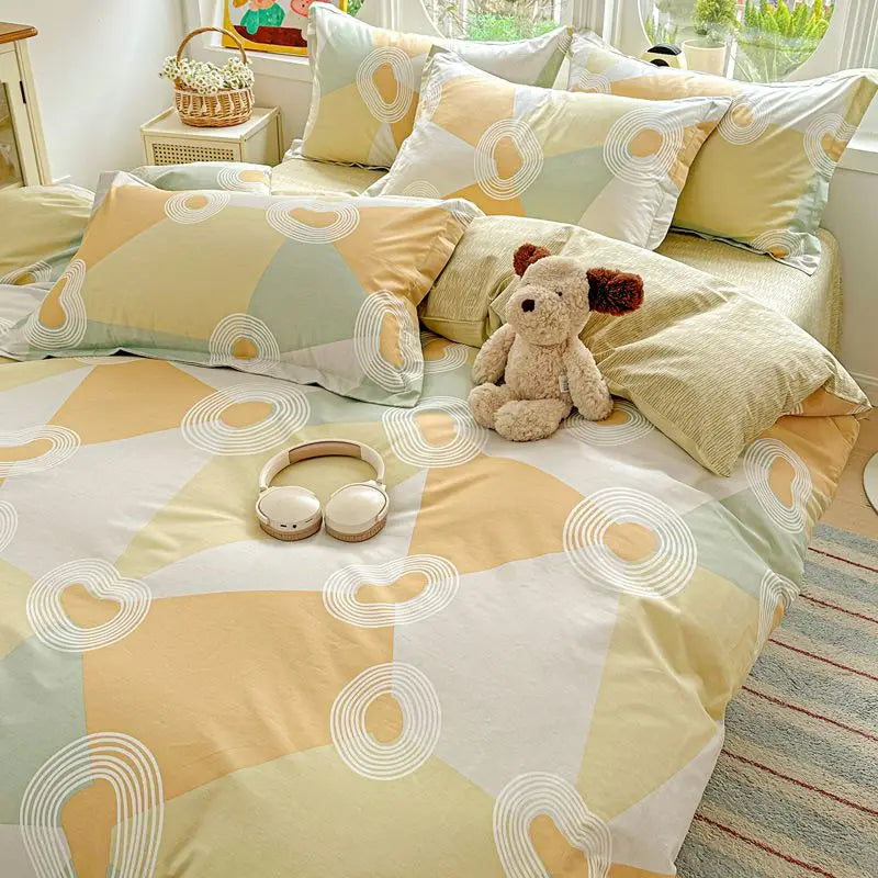 A light yellow and sage green duvet and pillow set featuring a geometric pattern with white circular accents.