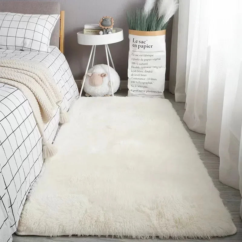 A fluffy white silk wool floor rug placed in a bright interior setting with a plant and decorative items.