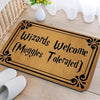 A brown entrance mat with black lettering that reads Wizards Muggles Welcome Tolerated