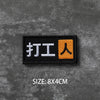 Black embroidered badge with Chinese characters for hook and loop applications on a gray textured background