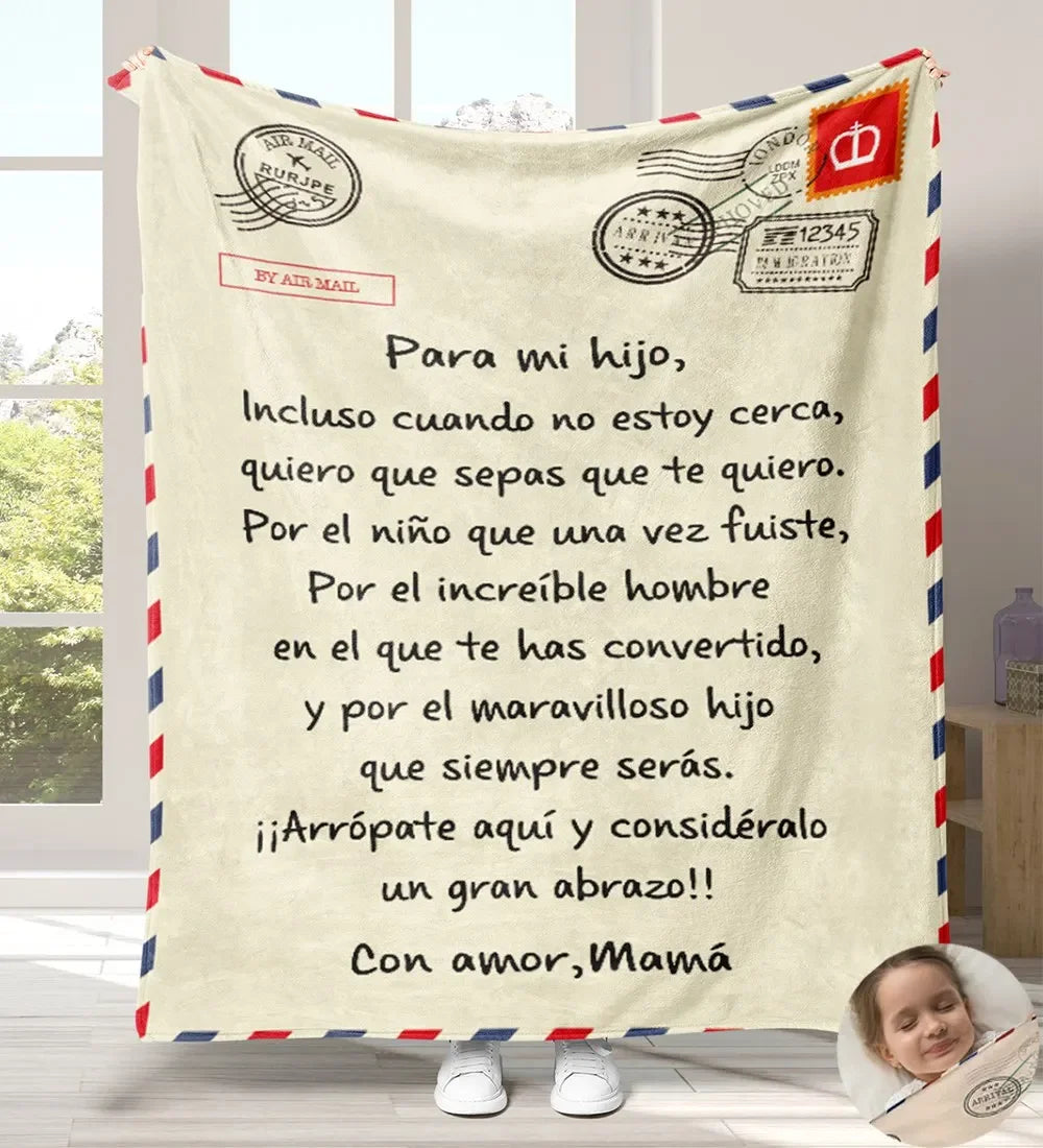 A cream colored flannel throw blanket featuring a handwritten Spanish message on it.