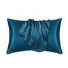 A dark teal luxury mulberry silk pillow cover folded and displayed against a white background.