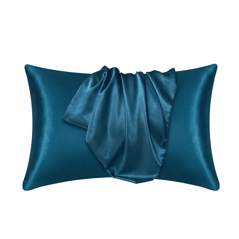 A dark teal luxury mulberry silk pillow cover folded and displayed against a white background.