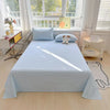 A light blue organic cotton bedding set displayed on a bed with a white frame and natural light.