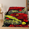A red and black print of a dinosaur head on a flannel throw blanket.