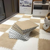 A stack of white and gray soft plush EVA foam play mat tiles on a beige tiled floor.