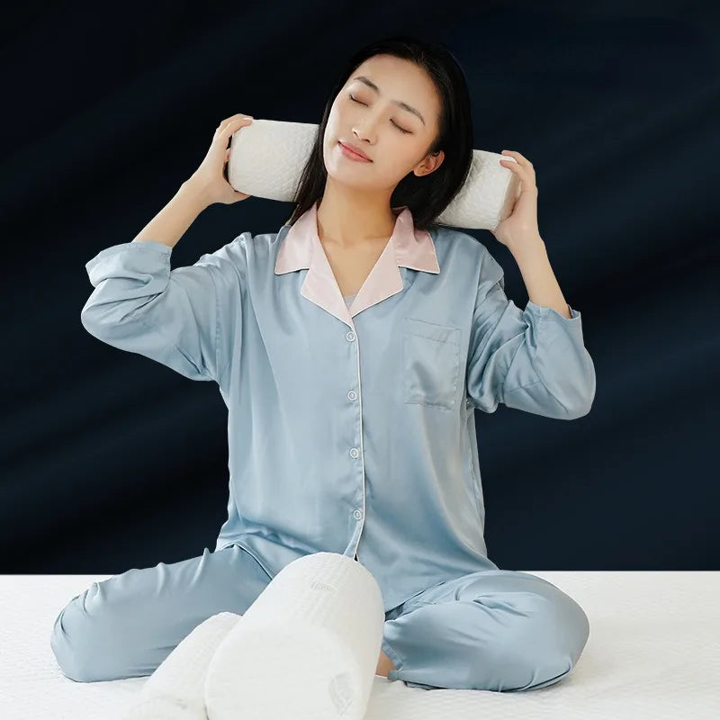 A woman is relaxing with a light blue memory foam neck roll pillow on her shoulders.