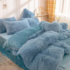A fluffy blue mink velvet duvet set with matching pillows and a yellow plaid curtain in a bright room.