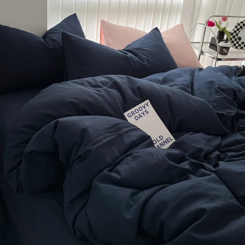 A dark navy blue duvet cover set with matching pillows and a white tag reading Groovy Days Old Annel.