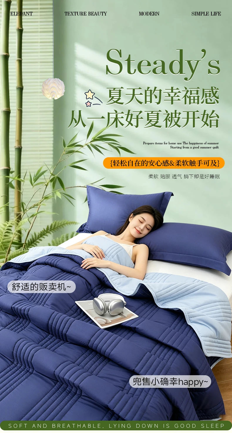 A woman is relaxing on a bed covered with a blue quilted blanket, enjoying a peaceful moment.