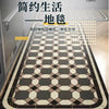 A patterned floor mat featuring geometric designs in shades of gray and beige, used for kitchen or entrance areas.
