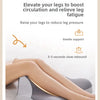 A person's legs are resting on a gray ergonomic wedge pillow designed to boost circulation and relieve fatigue.