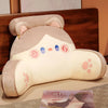 A beige plush sofa cushion shaped like a cute animal face with pink accents.