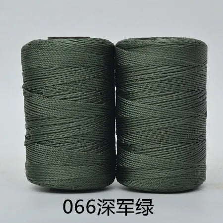 Two spools of dark green yarn or cord for crafting