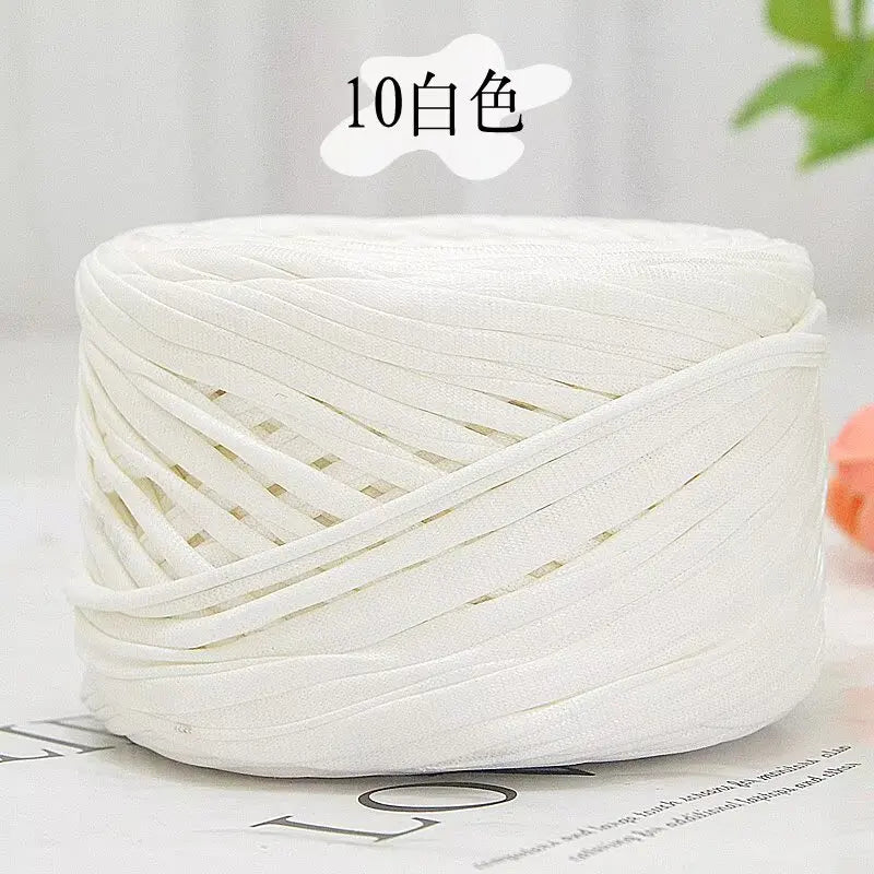 A ball of white metallic cake yarn for crafting, shown in a close-up view.