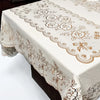 A white rectangular dining table cloth with brown floral embroidery and lace trim.