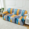 A colorful stretch sofa slipcover featuring geometric patterns in shades of blue, orange, gray, and white.