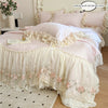 A pink and cream Korean style lace embroidered duvet set displayed on a bed with decorative pillows.