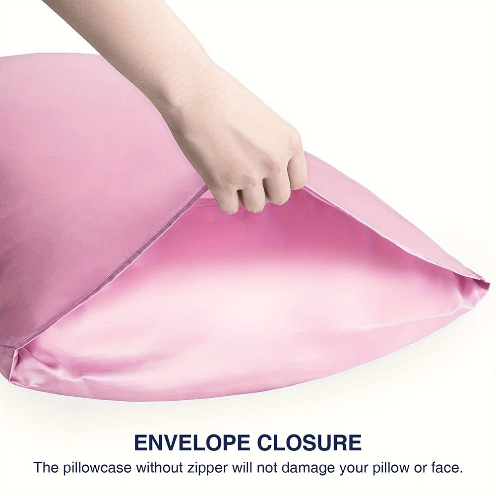 A hand is opening a pink satin pillowcase with an envelope closure to show the interior.
