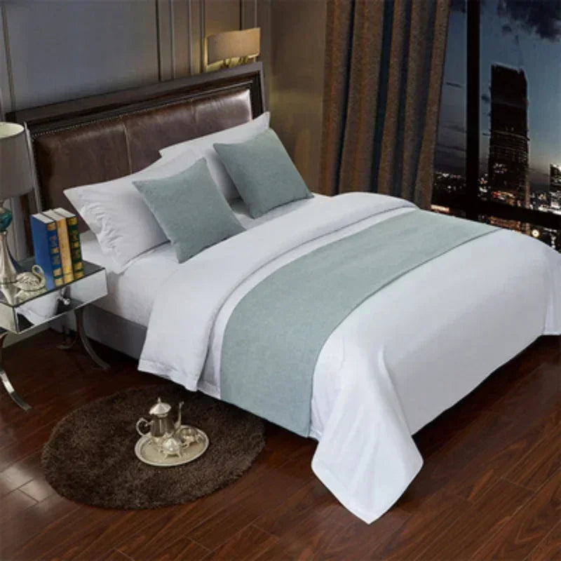 A luxurious bedroom featuring a bed with white linens and light blue decorative pillows.