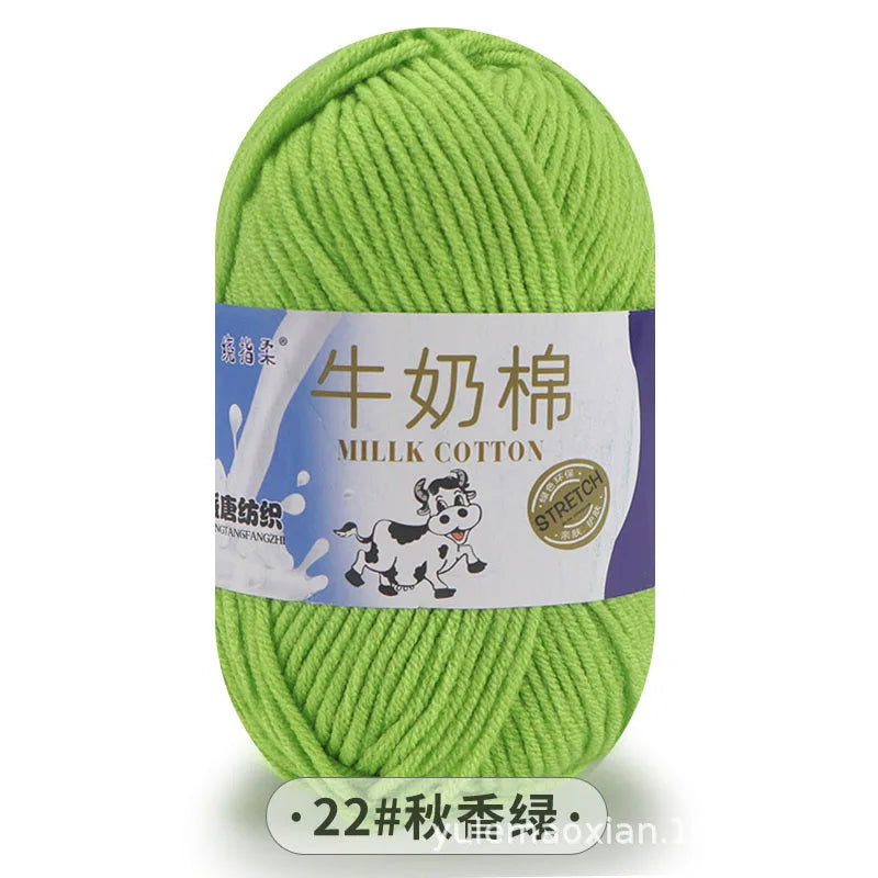 A ball of light green milk cotton yarn with a white label featuring Chinese text and an illustration of a cow.