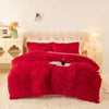 A vibrant red plush duvet cover set displayed on a bed with light cream bedding and bedside tables.