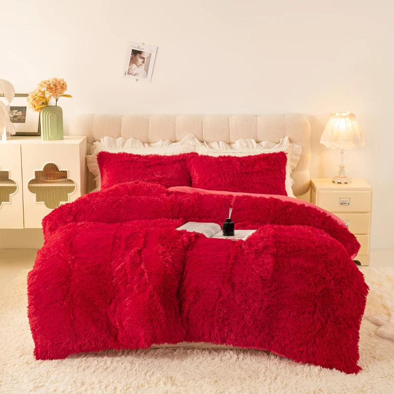 A vibrant red plush duvet cover set displayed on a bed with light cream bedding and bedside tables.