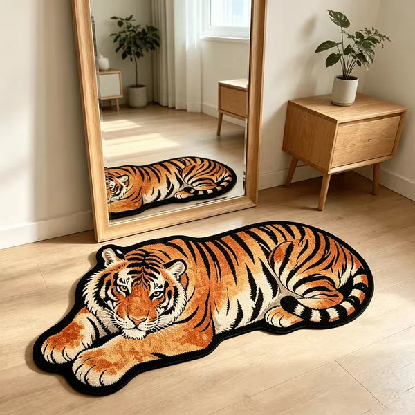 An orange and black tiger plush cartoon area rug lying on a light wood floor in front of a large mirror.