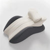 A beige ergonomic memory foam wedge pillow with a dark gray cover shown from the side.