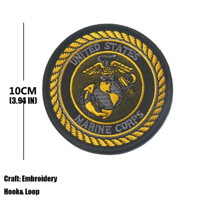 A round, black embroidered patch featuring the United States Marine Corps emblem in gold thread.