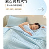A woman is sleeping comfortably under a light blue breathable waffle quilt in a bedroom setting.