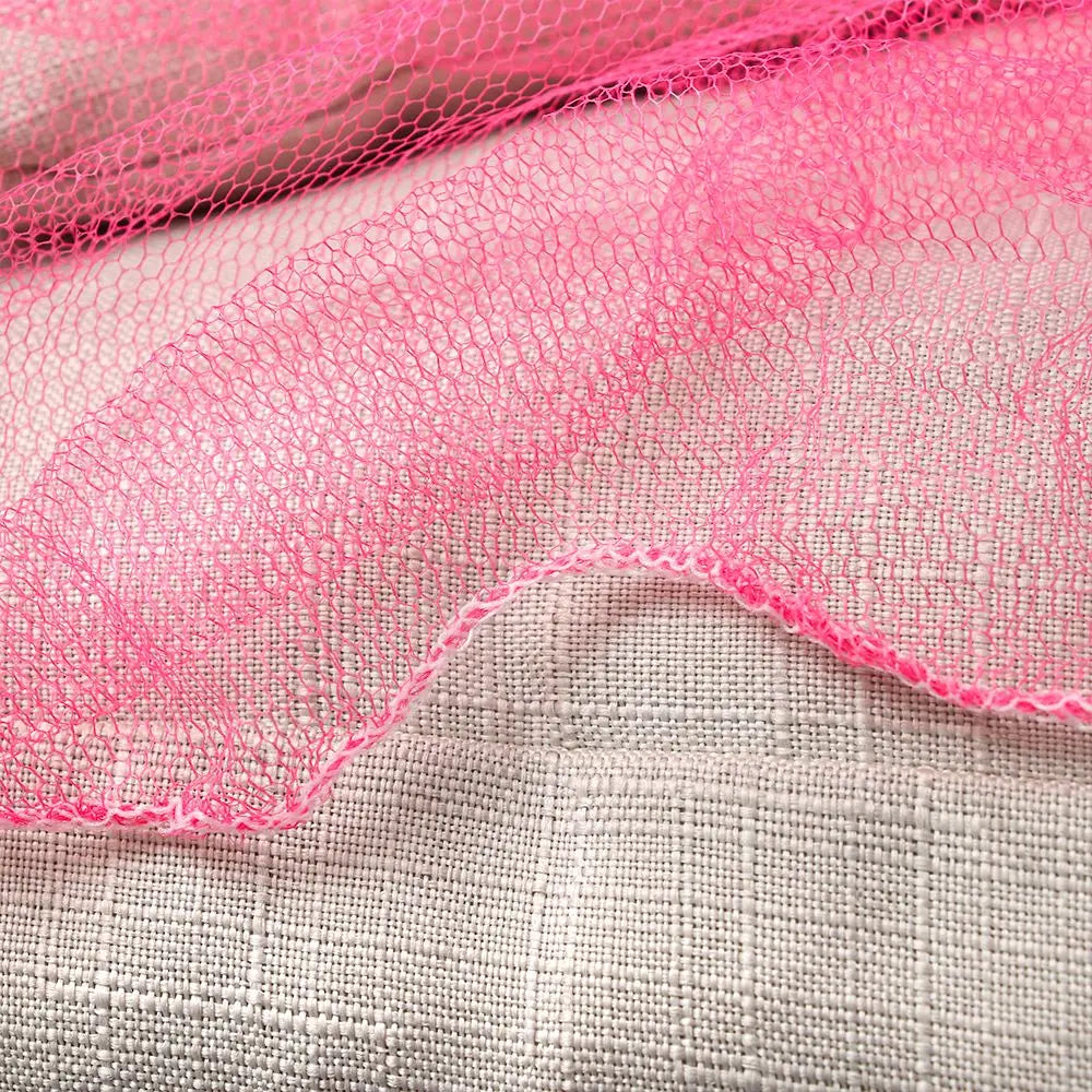 Pink lace dome mosquito net canopy draped over a light gray fabric surface.
