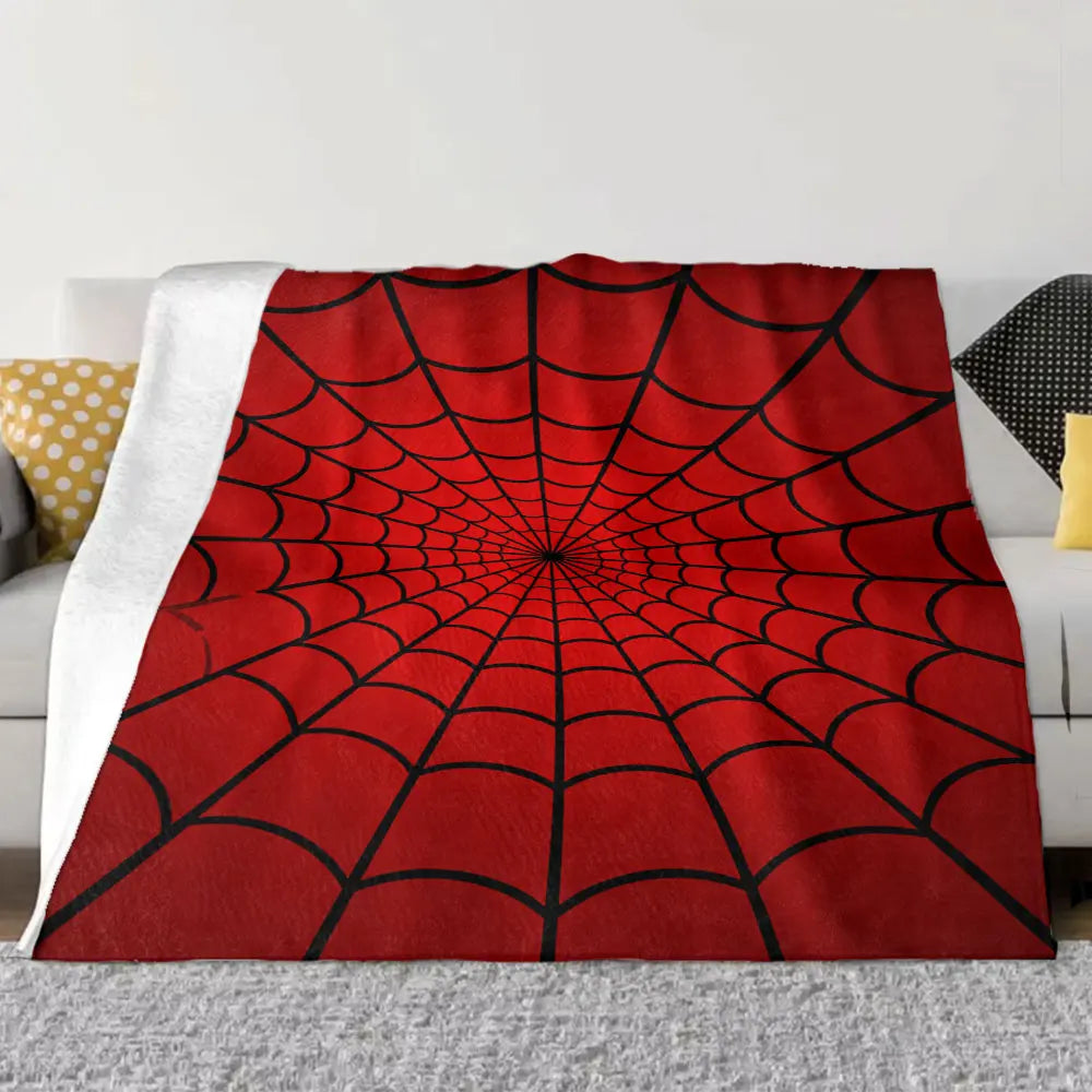 A symmetrical red spider web patterned throw blanket with white trim draped on a sofa.