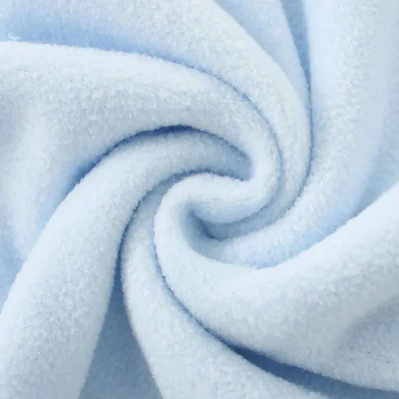A soft light blue fleece throw blanket with a textured, fluffy appearance, tightly rolled.