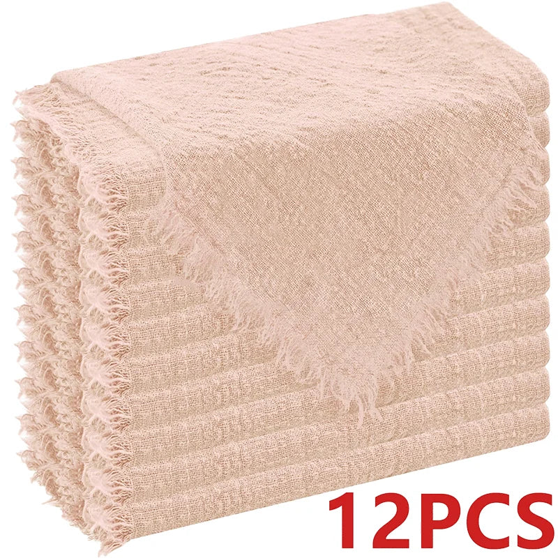 A stack of light pink decorative cloth napkins with fringed edges.