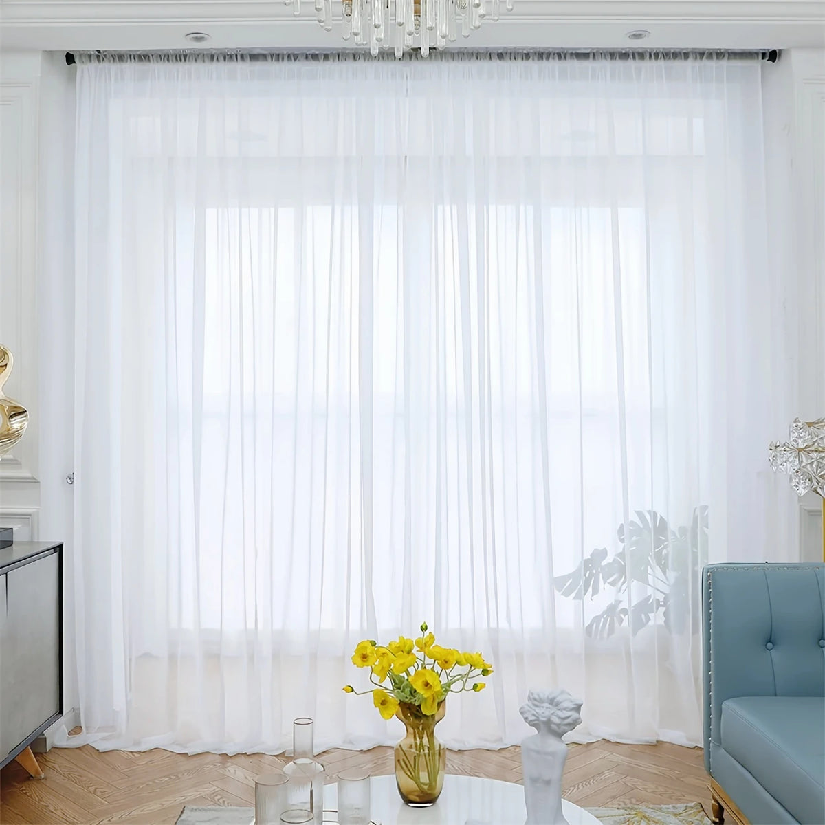 White semi-sheer tulle curtains with a delicate floral texture hanging in a bright room.