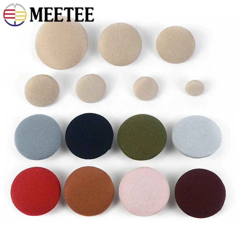 A set of round fabric-covered shank buttons in various shades of beige, gray, black, and reddish-brown.