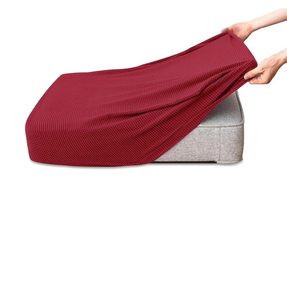 A maroon polar fleece jacquard sofa seat cushion cover being held by a hand, resting on a gray cushion.