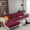 A modern, deep magenta sofa with light beige cushions and a patterned throw pillow in a living room setting.