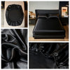A set of black satin bedding includes a fitted sheet, flat sheet, and pillowcases with an elastic band.