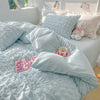 A light blue textured duvet cover set with matching pillows on a bed.