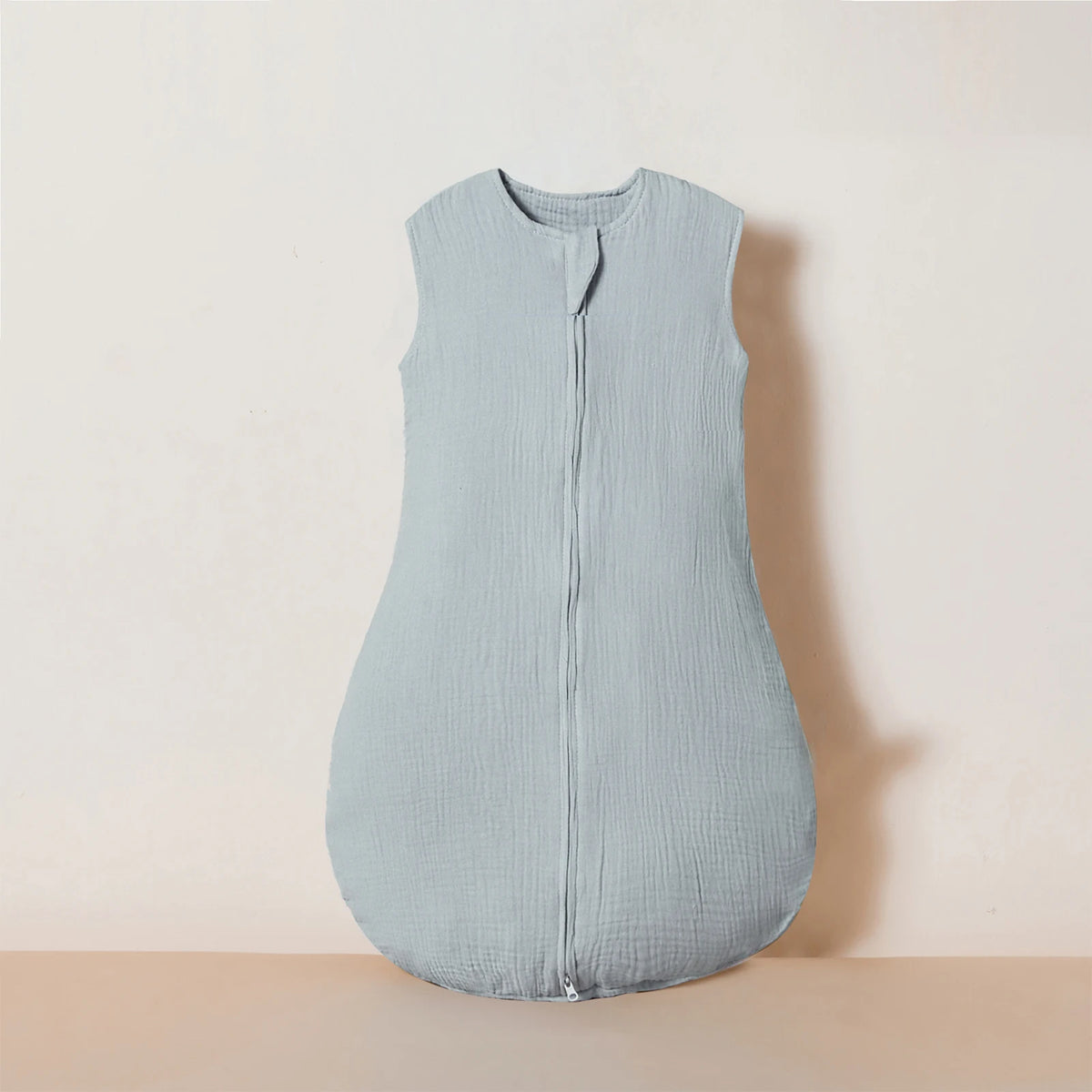 A light blue muslin cotton baby sleeping bag laid flat against a neutral background.