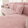 A pink universal elastic sofa cover with a full backrest and decorative pillows shown in a bright room.